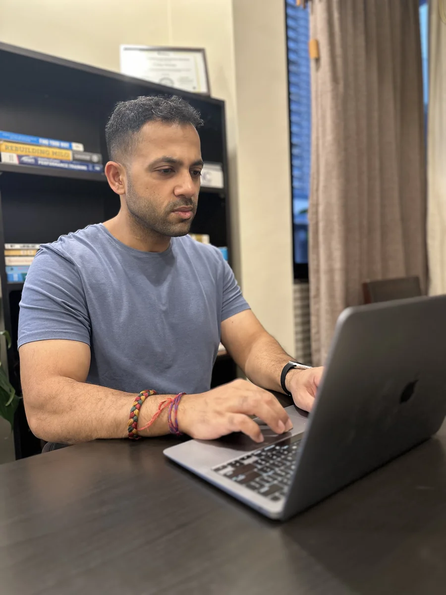 Coach reviewing a client's training plan on a laptop